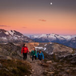 Three hikers enjoy the mountain glow on Whistler Blackcomb.