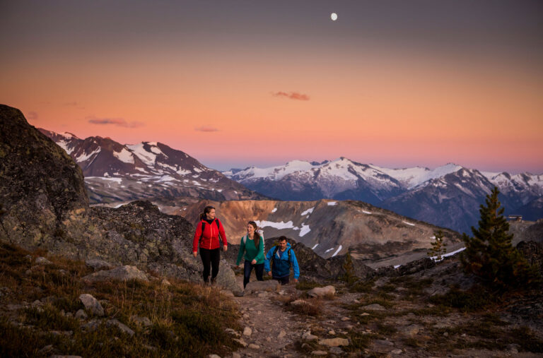 Three hikers enjoy the mountain glow on Whistler Blackcomb.