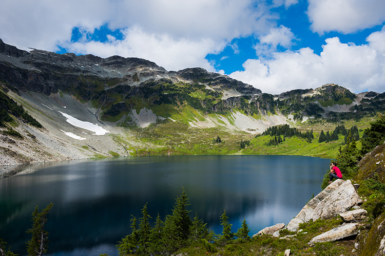 Woman sitting on rock at Cirque Lake in Whistler