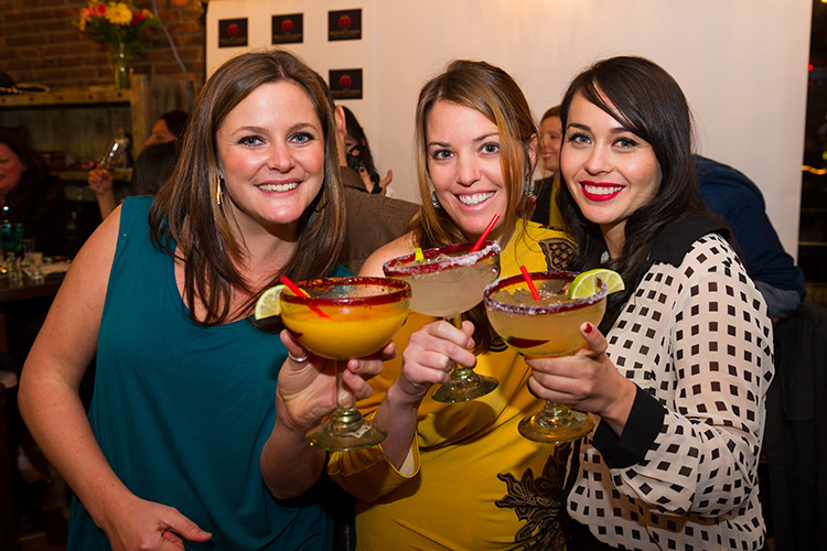 Three women holding margaritas at the Mexican Corner