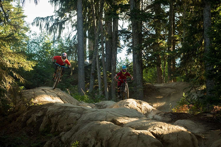 Two riders on a rock roll in the Creek Zone