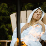 A woman relaxes in a chair by the fire at the Scandinave Spa in Whistler.