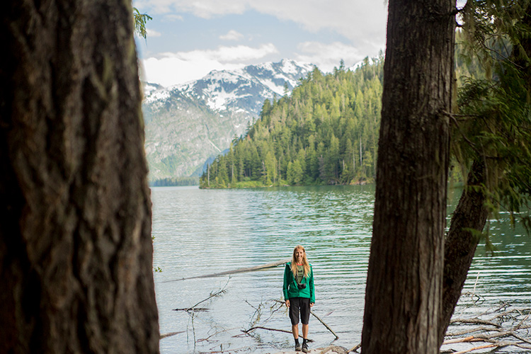 Hiker standing on log in Cheakamus Lake