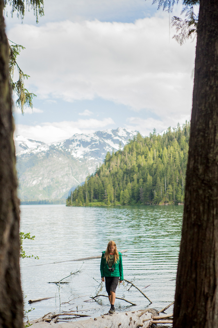 Hiker standing on a log in Cheakamus Lake