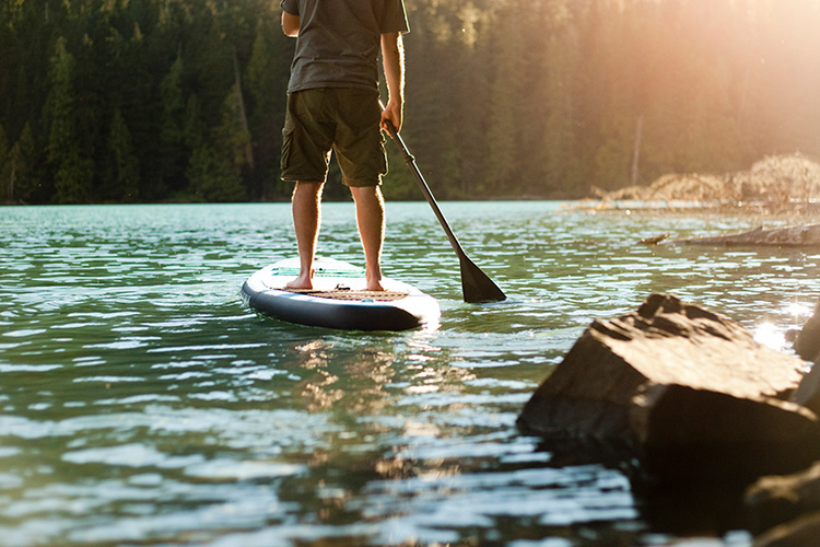 Paddleboarder leaving the shore of Cheakamus Lake