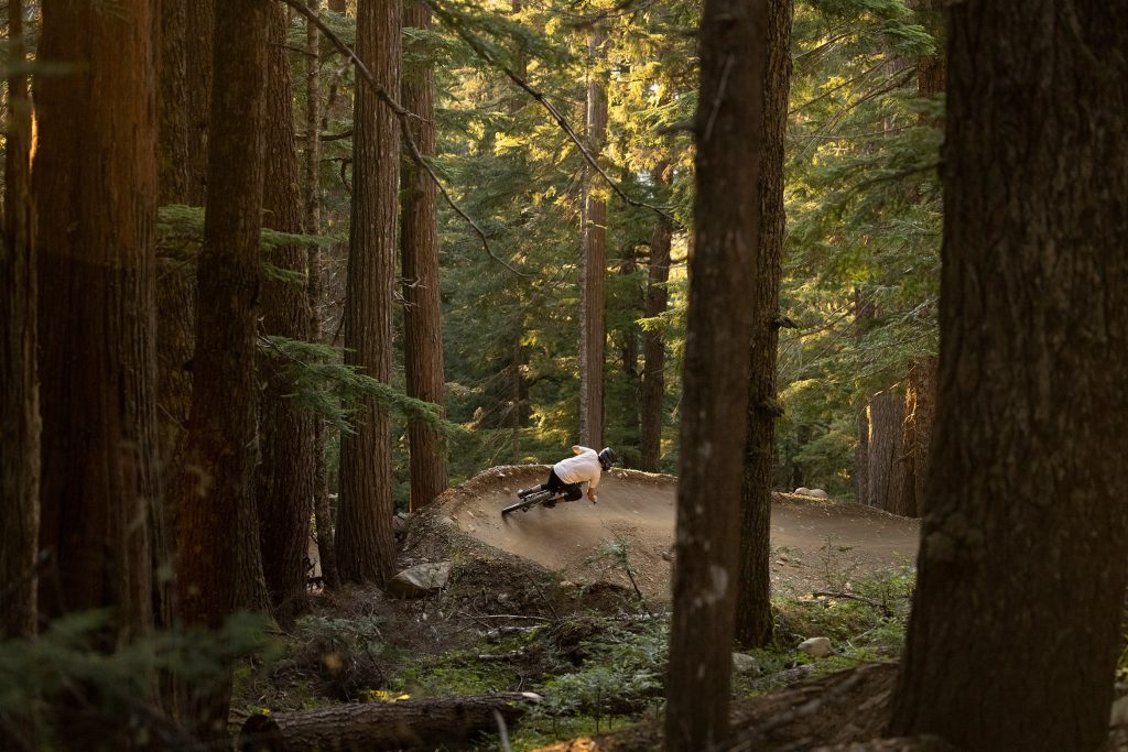 A mountain bike rider makes their way around a berm in the Whistler Mountain Bike Park.
