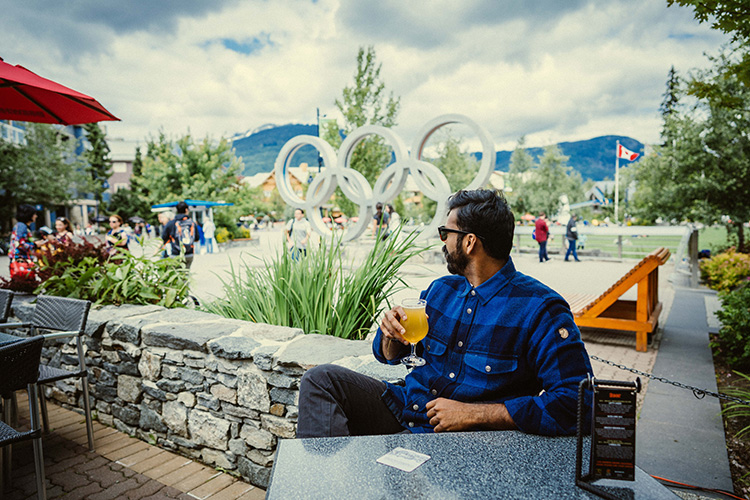 Person enjoying a beer in front of the Olympic Rings 