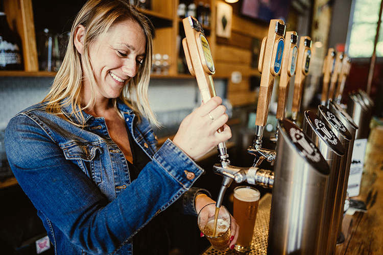 Bartender at Whistler Brewing Co pulling a beer