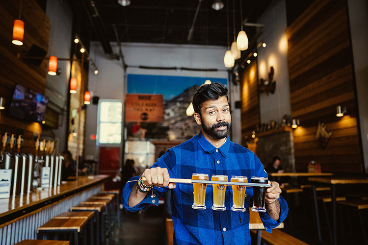 Patron holding a beer flight at Whistler brewing Co