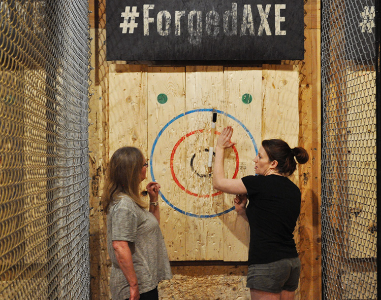 Instructor helping guest at Forged Axe Throwing