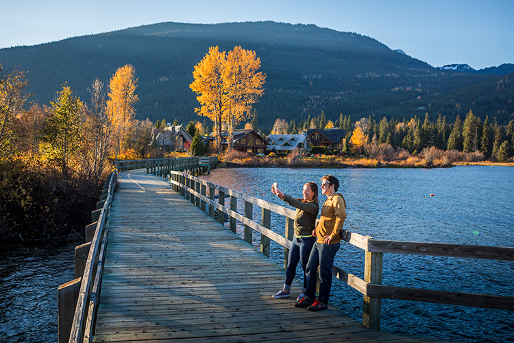 Couple fall sightseeing at Green Lake in Whistler