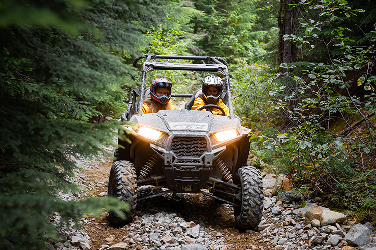 Guests driving a RZR over rocks