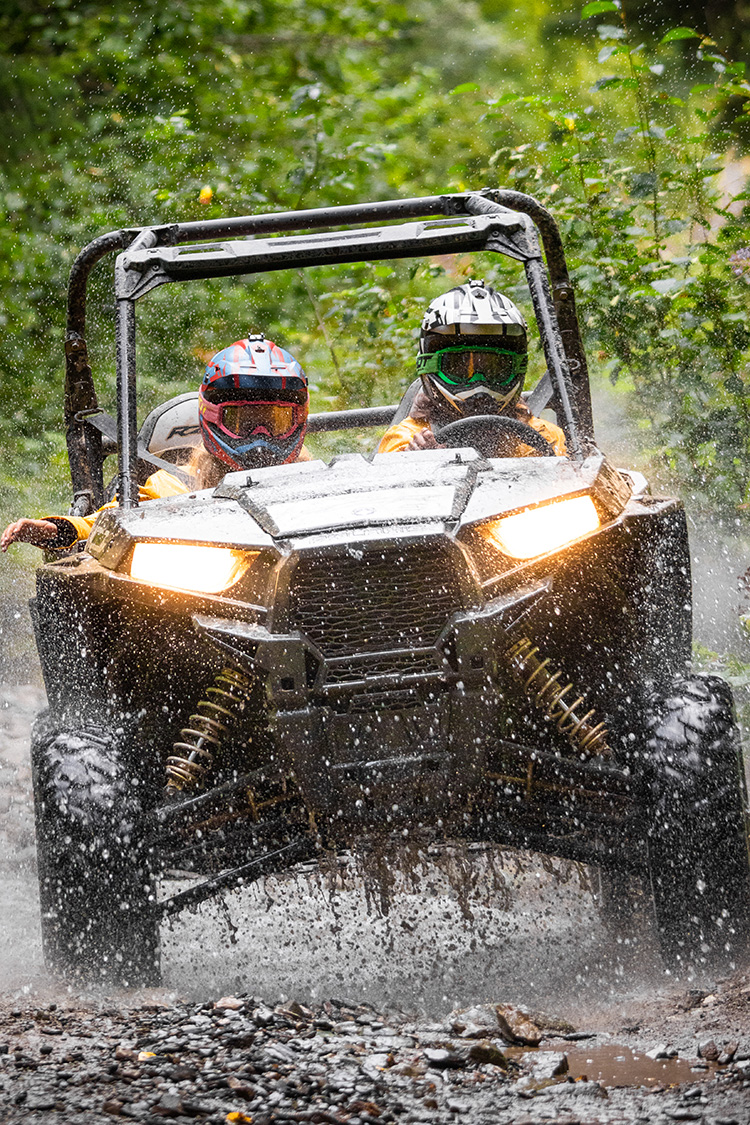 Guests driving RZR through mud