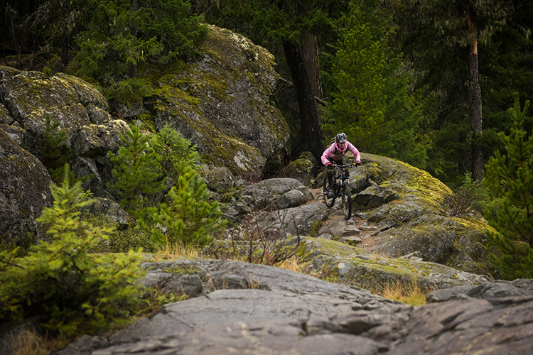 Rider on a rock roll riding cross country trail in Whistler