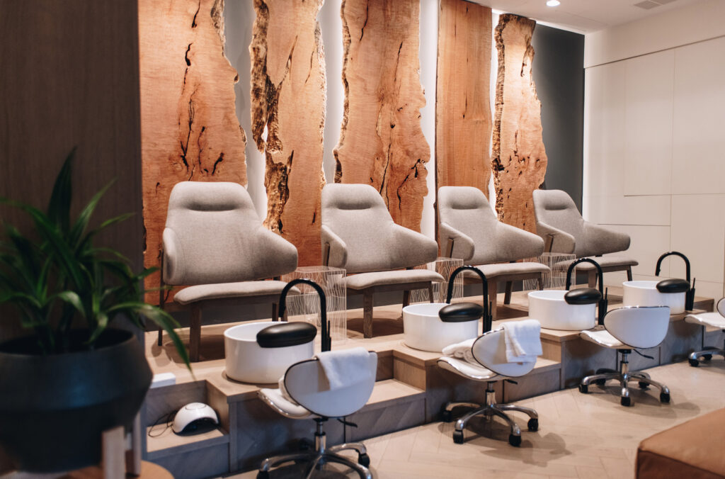 The pedicure room at Nita Lake Lodge has four large seats with sinks at their feet and live-wood back boards behind.