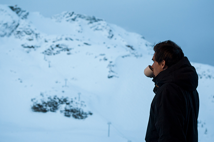 Person drinking coffee looking at Whistler Mountain