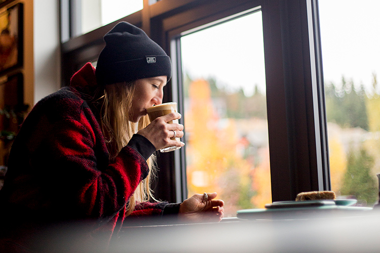 Person drinking coffee in front of a window