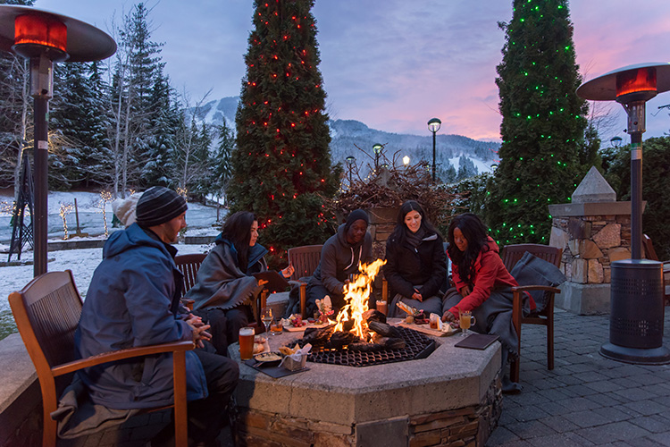 Friends around a fire on a patio in Whistler