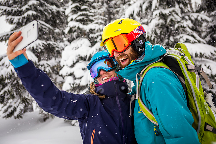 A couple taking a selfie in while snowboarding in Whistler 