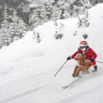 A skier dressed as Santa riding a reindeer charges down the slopes of Whistler Blackcomb.