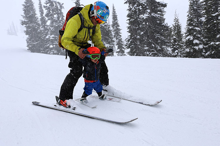 A father and his toddler ski on Whistler Mountain