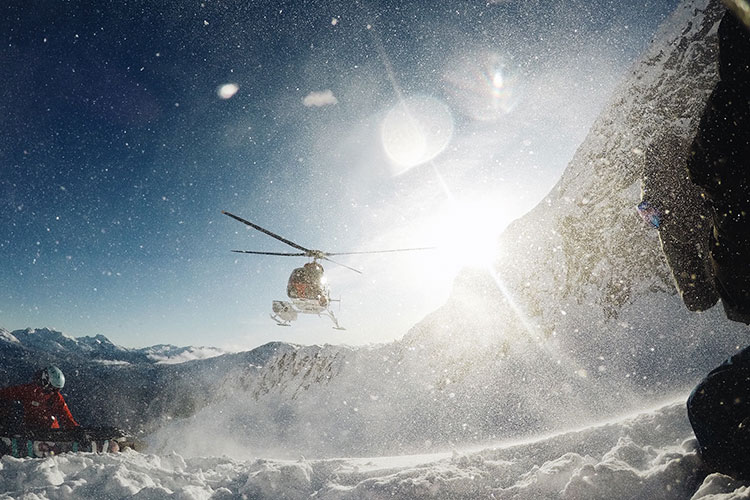 A helicopter takes off after dropping a snowboarder on the mountain in Whistler