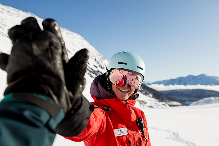 A whistler heli-skiing guide high fives a great slope experience