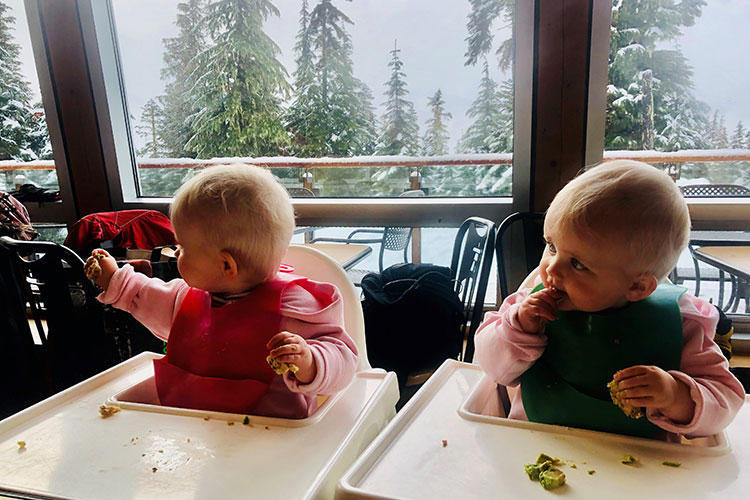 Twin babies sit in highchairs eating at the cafe at Whistler Olympic Park.