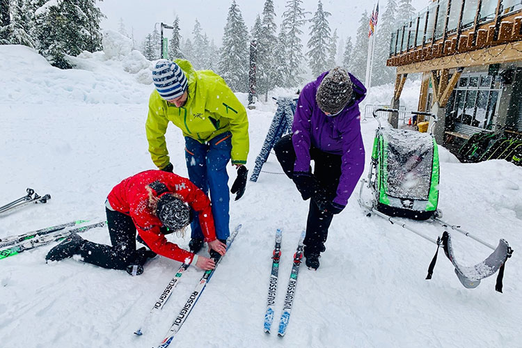 A couple get their cross country skis on at Whistler Olympic Park.