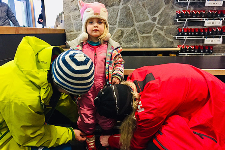 A toddler gets cross country gear on at Whistler Olympic Park.