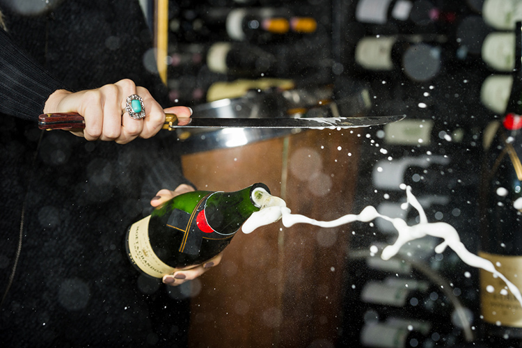 A bottle of champagne being opened by saber at the Bearfoot Bistro