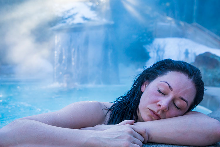 A woman enjoys the hot pool at the Scandinave Spa Whistler