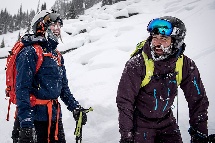 Two skiers laugh together after a powder run on Whistler Mountain.