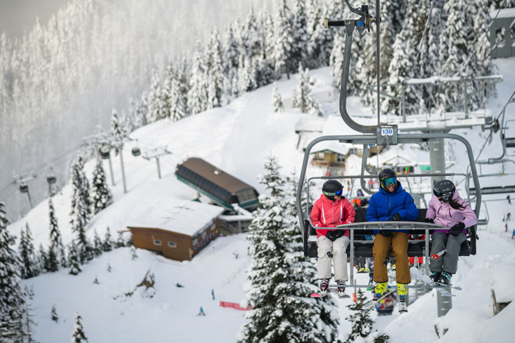 Skiers on a chairlift in Whistler.