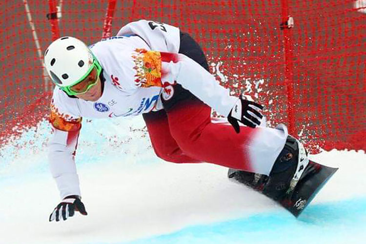 Tyler Mosher competing as a Paralympian on his snowboard