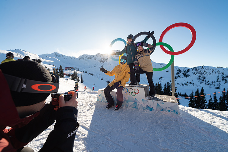 Family getting a photo taken in front of Olympic Rings in Whistler