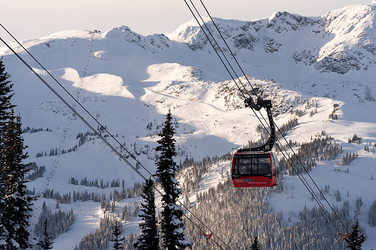 A red Peak 2 Peak gondola cabin against a mountain backdrop