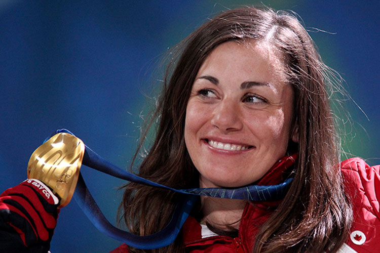 Maelle Ricker holding up her gold medal at the 2010 Olympic Winter Games.