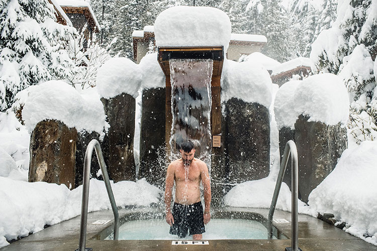 A man stands under the cold fountain at the Scandinave Spa in Whistler.