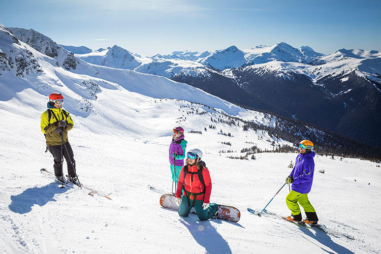 Friends gather on a ski run in the sunshine on Whistler Blackcomb.