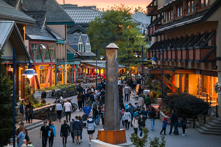 Crowds in Whistler Village walk down the stroll in the alpen glow.