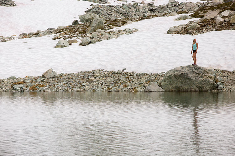 A woman looks over a glacial lake on Whistler Blackcomb.