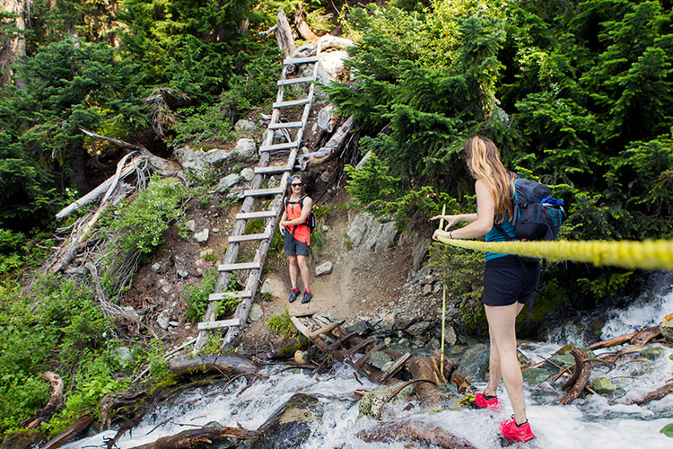 Two women cross a bridge in the Callaghan Valley.