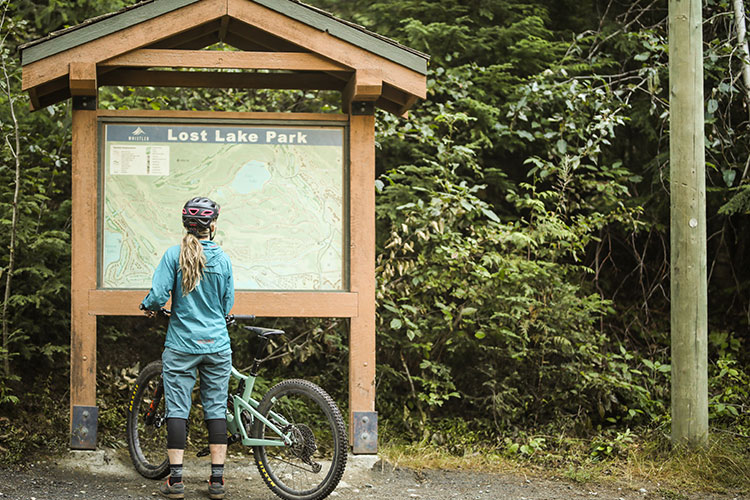 A mountain bikers examines a trail map at Lost Lake Park in Whistler.