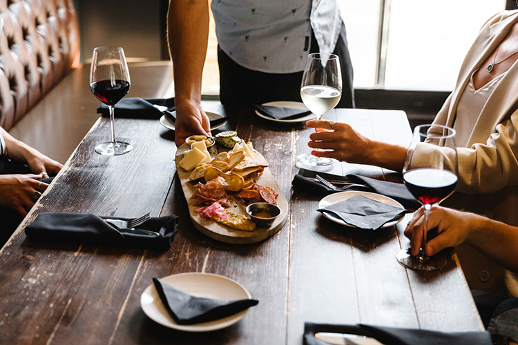 A server places a charcuterie board down on a table at Stonesedge Kitchen in Whistler.