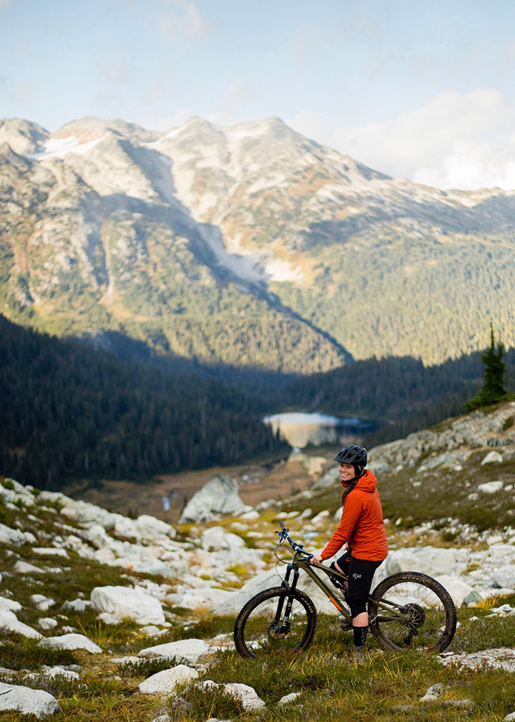 A mountain biker looks out at the view on the Lord of the Squirrels Trail in Whistler.