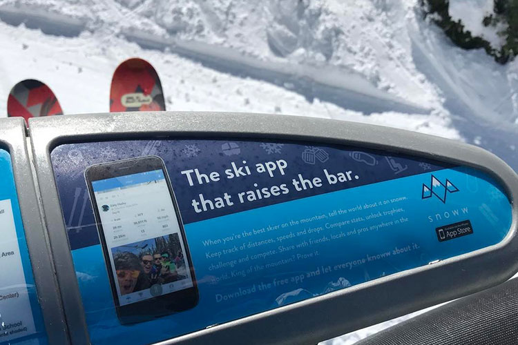 The ad for the Snoww app on a ski chair bar.