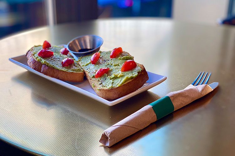 Two slices of avocado toast with cherry tomatoes presented on a plate at the Pangea Pod Hotel in Whistler.