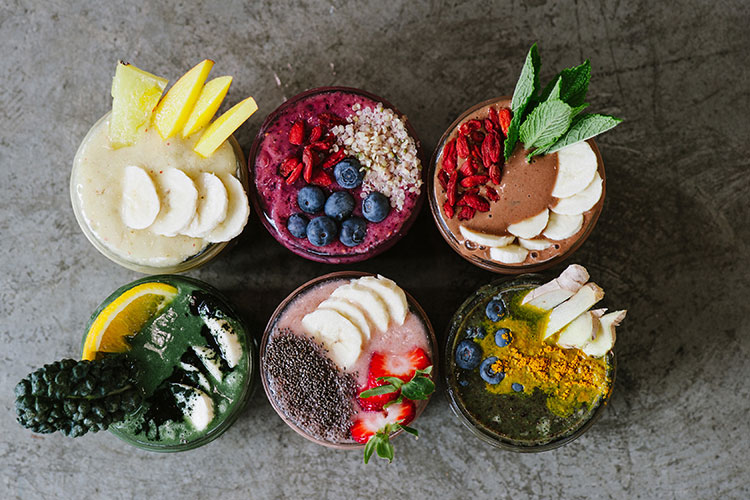 Six colourful smoothies from The Green Moustache seen from above.