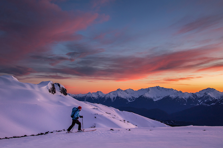 Skier going up the mountain against a sunset